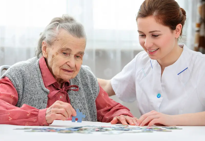 A senior woman and her caregiver do a jigsaw puzzle in Southeast and Southwest Houston, TX