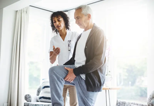 A physical therapist works with a man in his Southeast or Southwest Houston, TX home