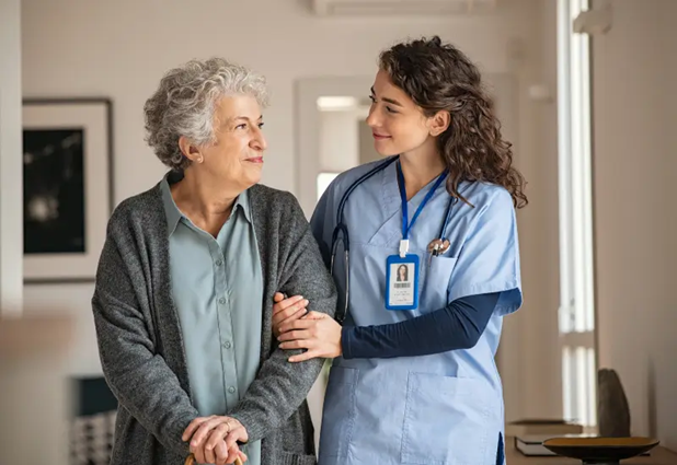 A private duty nurse locks arms with a senior patient in her Houston-area home